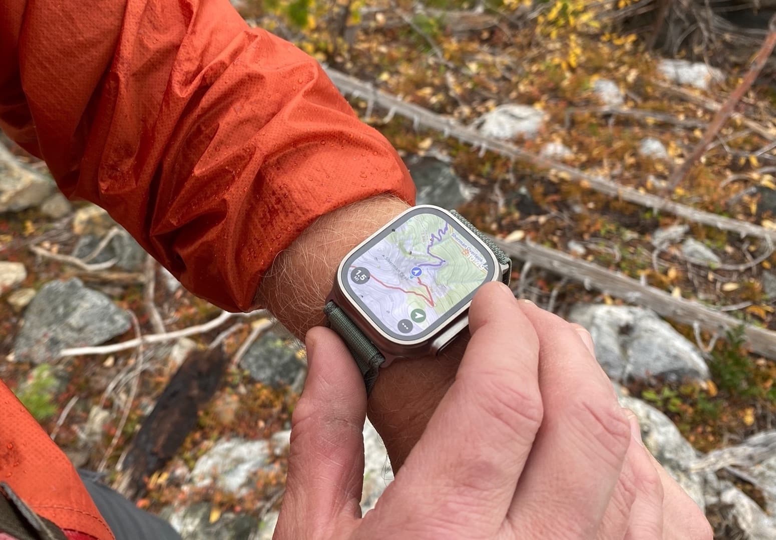 PHOTO: Apple Watch on a wrist, trail map at a junction